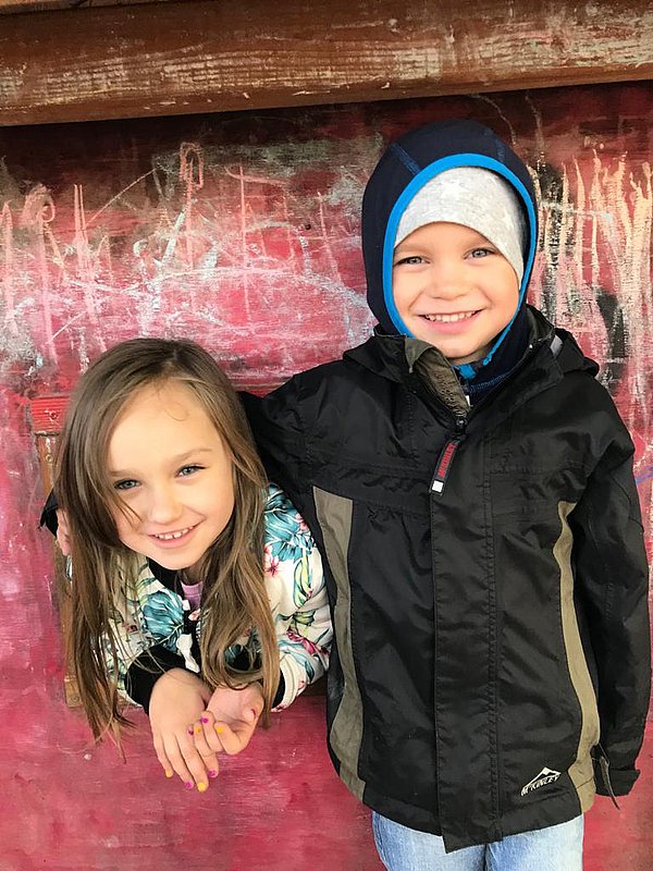 2 Lächelnde Kinder nebeneinander auf einem Spielplatz